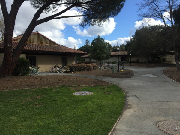 A path leads past a cluster of several stout buildings.