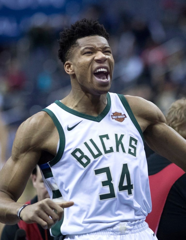 Giannis Antetokounmpo in a white Bucks jersey.