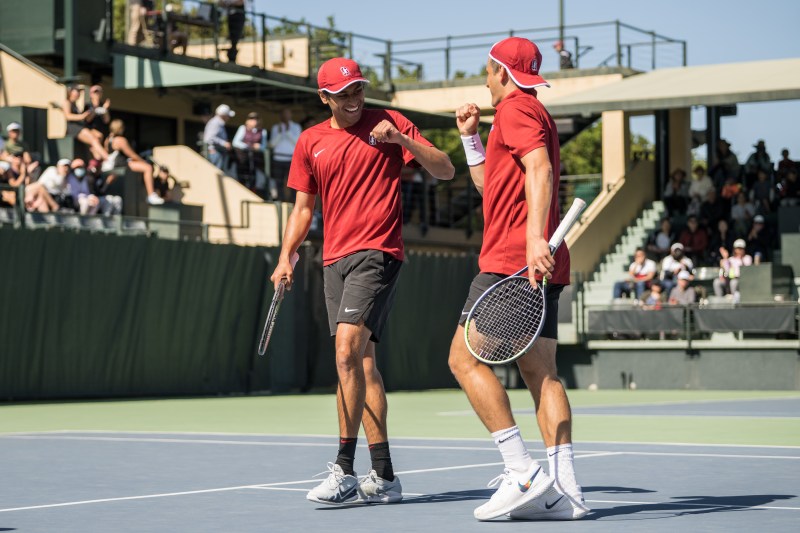 Two tennis players fist bump on the court