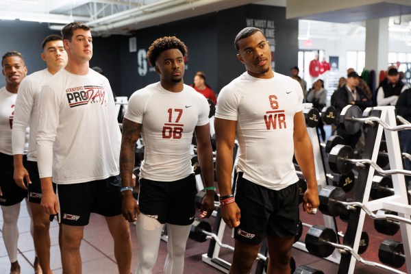 Players line up on pro day, wearing shirts identifying them by number and position.