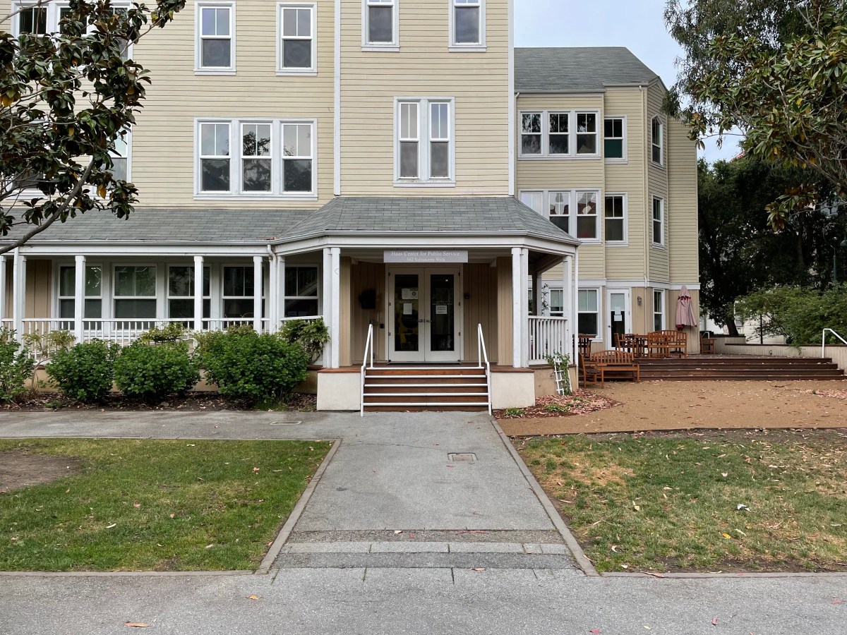 Picture of the Haas Center building - a cream yellow colored house with 3 floors and a veranda