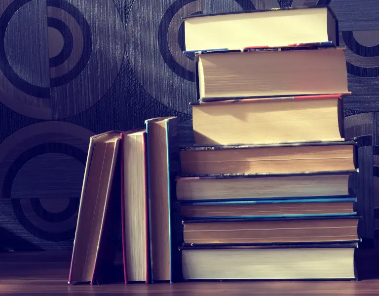 Stack of books against dark wood.