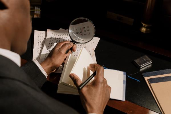 man is decoding characters using his magnifying glass