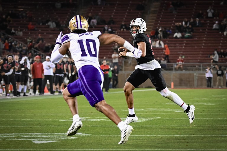 Two football players leap on the field.