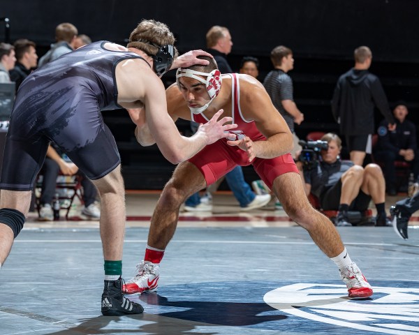 Two wrestlers hunker down on the mat.