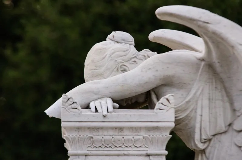 A sculpture of a women with her head in her hands.