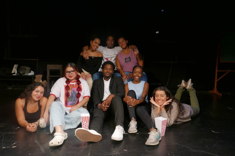 The cast of BLACKstage gather in front of a couch.