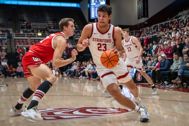 A player dribbles a ball towards the camera as an opponent approaches from the side.