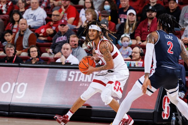 Kanaan Carlyle holds the ball on the court, in front of an Arizona defender