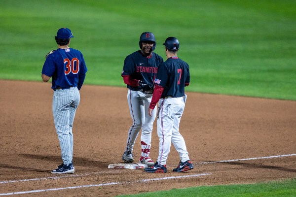 Two Stanford football players talk while on the diamond.