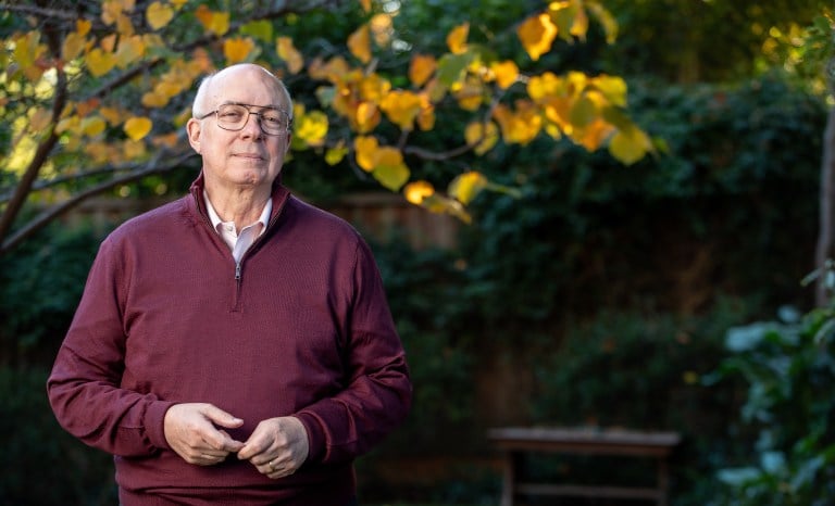 Joe Simitian poses in front of a yellow and green tree.