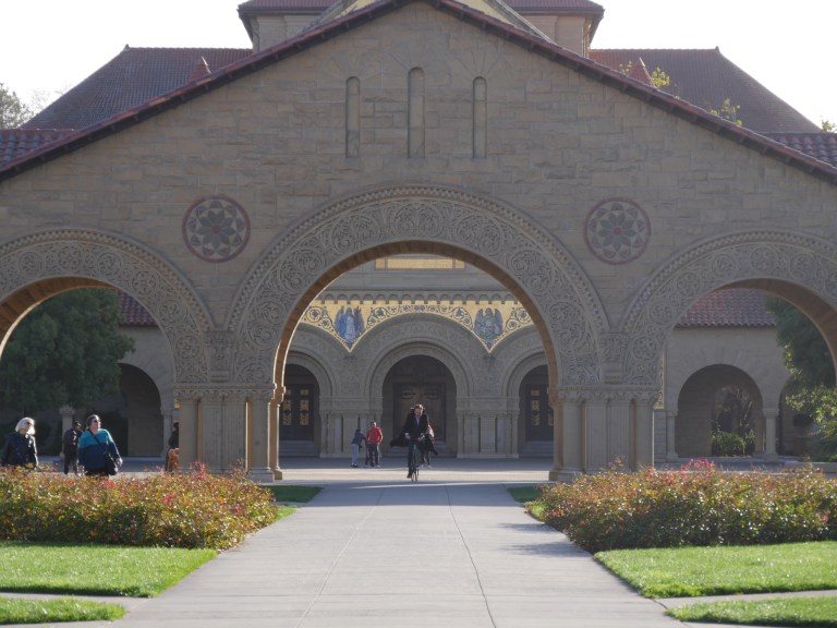 Memorial Church stands at the center of campus in the sunlight.