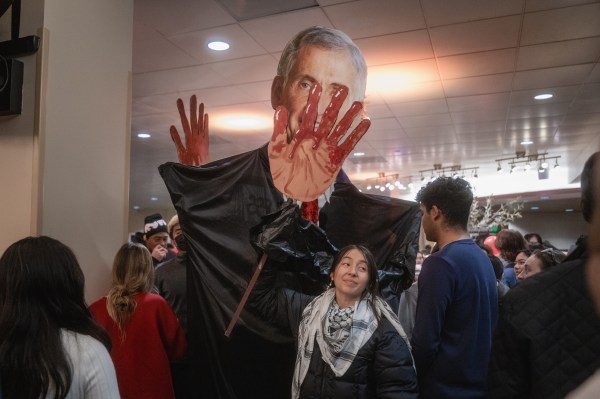 A cutout of Richard Saller's face with large hands covered in red.