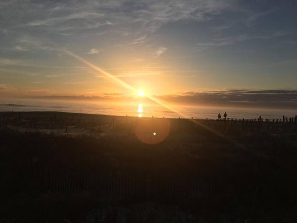 Sunset with silhouettes of people by the beach.