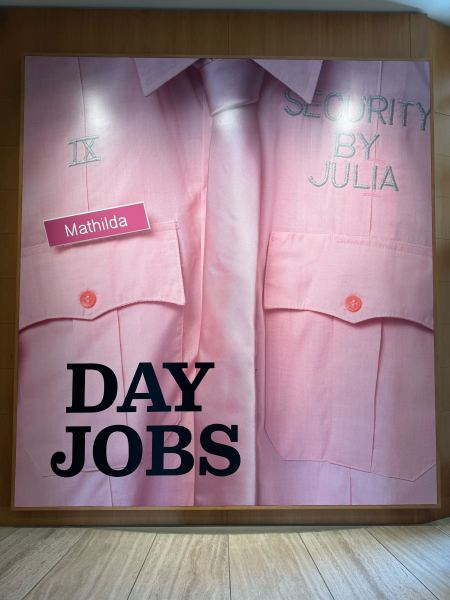 A large painting of a pink button-up shirt and tie with "Security by Julia" and a nametag attached to the shirt. The words "Day Jobs" is written across the bottom of the canvas.