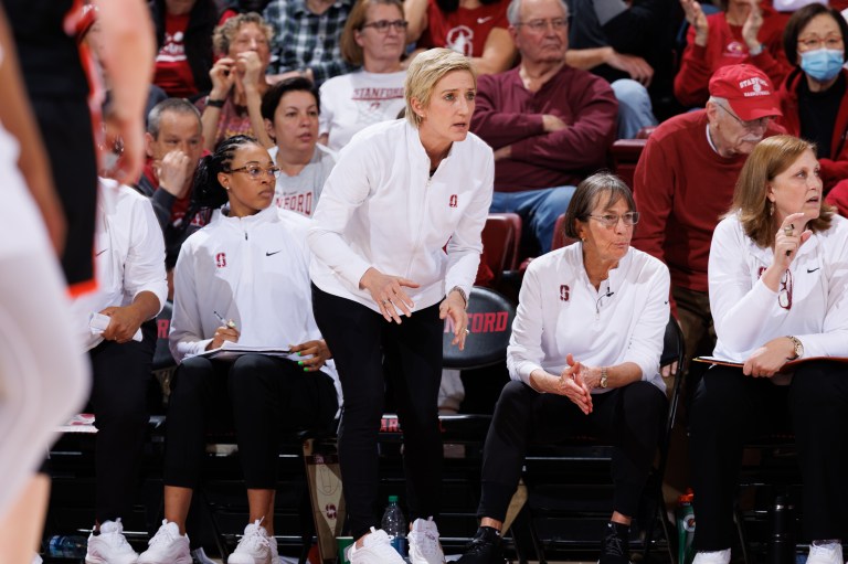 Kate Paye standing up on the slidelines during a game at Maples Pavilion