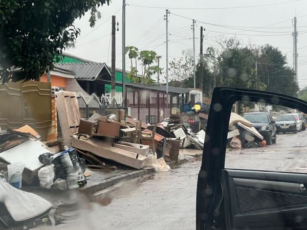 A street covered in water with damaged property visible.