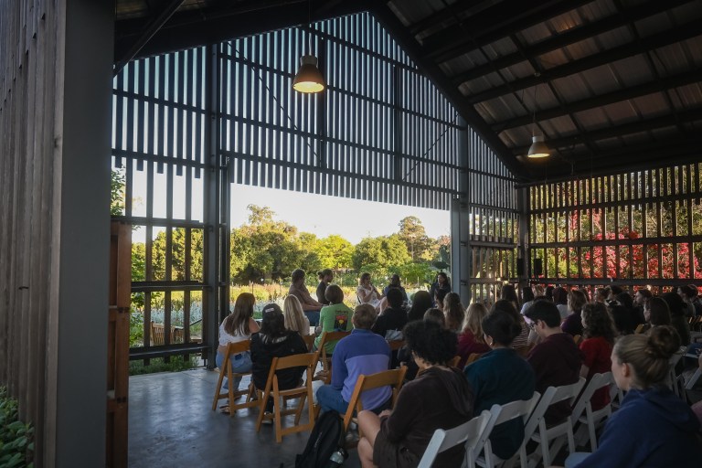 Students sit in a circle of chairs while participating in the rural panel.