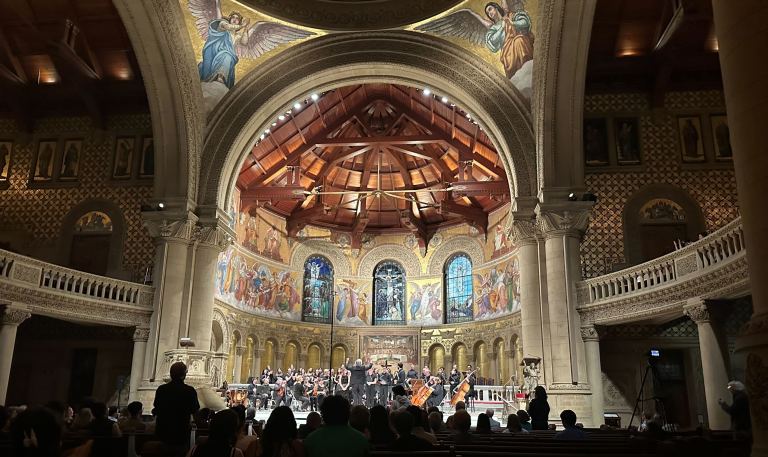 University Singers performing at Memorial Church with an accompanying orchestra.