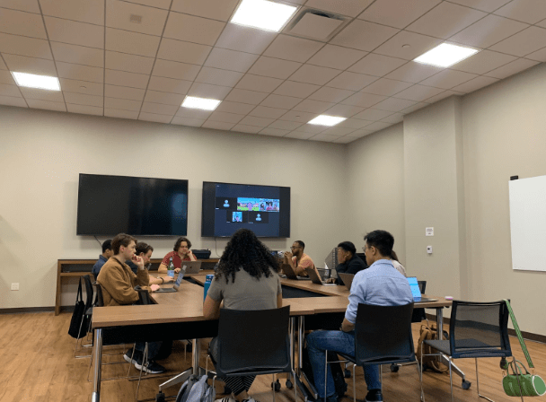 A group of Graduate Student Councilors sit around a table in a well-lit room.