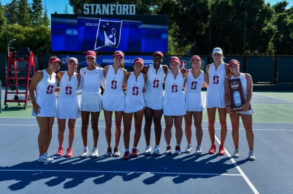 the women's tennis team stands in a line on the tennis court