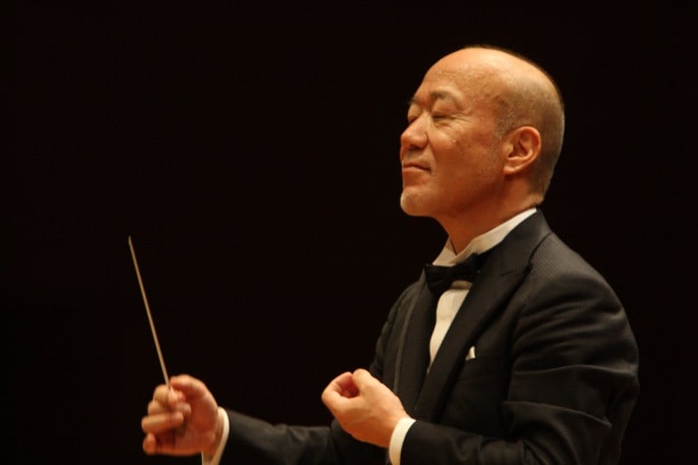 Composer Joe Hisaishi waves a conductor's baton with his eyes closed