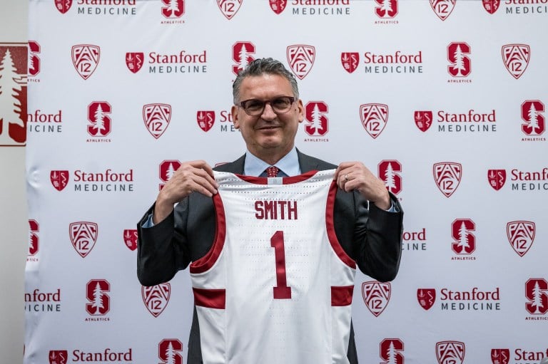 Kyle Smith holding basketball jersey