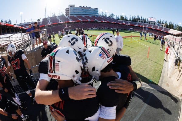 Stanford quarterbacks huddle together.