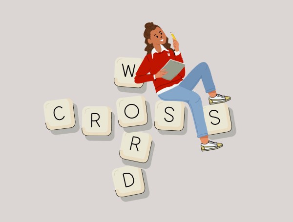 A woman sitting on letters that spell "Crossword"