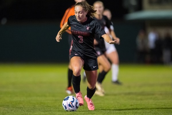 Soccer player dribbles ball in game.