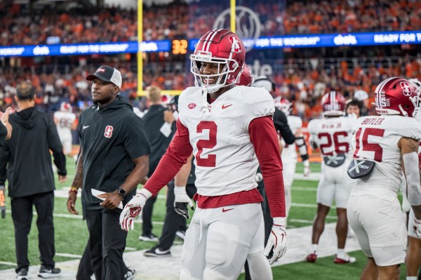 Football player standing on the sidelines during a game.