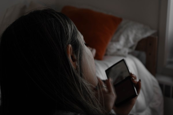 Photo of a girl's head looking at her phone