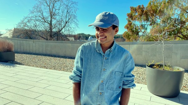 Headshot of Janani Balasubramanian; they are wearing a blue shirt and matching blue hat and turning slightly to the left, smiling.